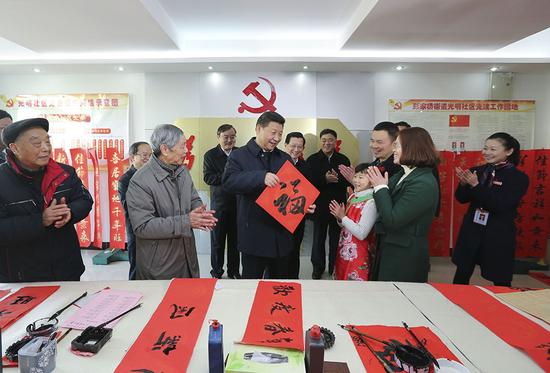 2016年2月3日，習(xí)近平在南昌市東湖區(qū)彭家橋街道光明社區(qū)書畫室，接過一位小朋友現(xiàn)場(chǎng)書寫的 “福”字，祝大家都幸福。新華社記者 蘭紅光 攝
